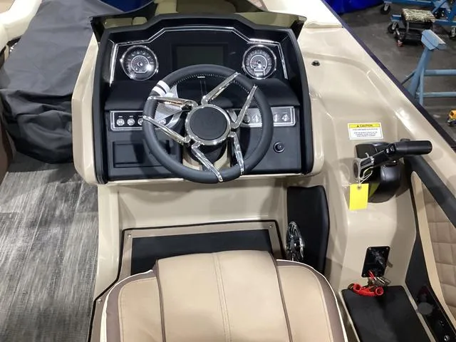 Slide: The Image of 2024 Godfrey Aqua Patio Entertainment 255 CBE boat dashboard with modern steering wheel and controls. - 20