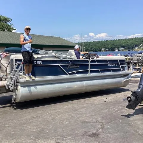 Slide: The Image of 2019 Godfrey Sw2286SB pontoon boat at dock with two people onboard. - 1