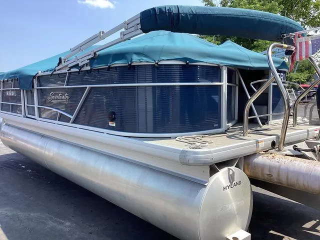 Slide: The Image of 2019 Godfrey Sw2286SB pontoon boat with blue canopy and aluminum pontoons. - 2