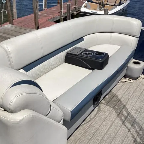 Slide: The Image of 2019 Godfrey Sw2286SB boat seating with cup holders, docked by the water. - 4