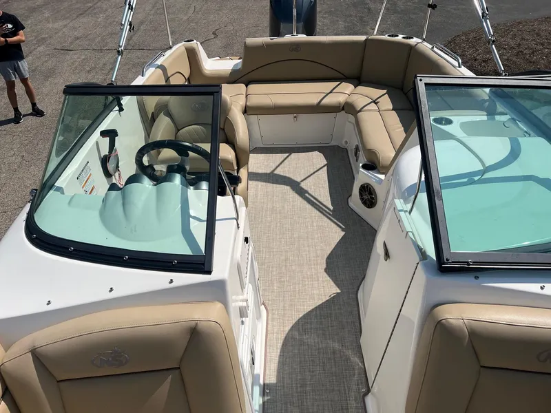 Slide: The Image of 2020 NauticStar 223 DC boat interior with beige seating and dual consoles. - 5