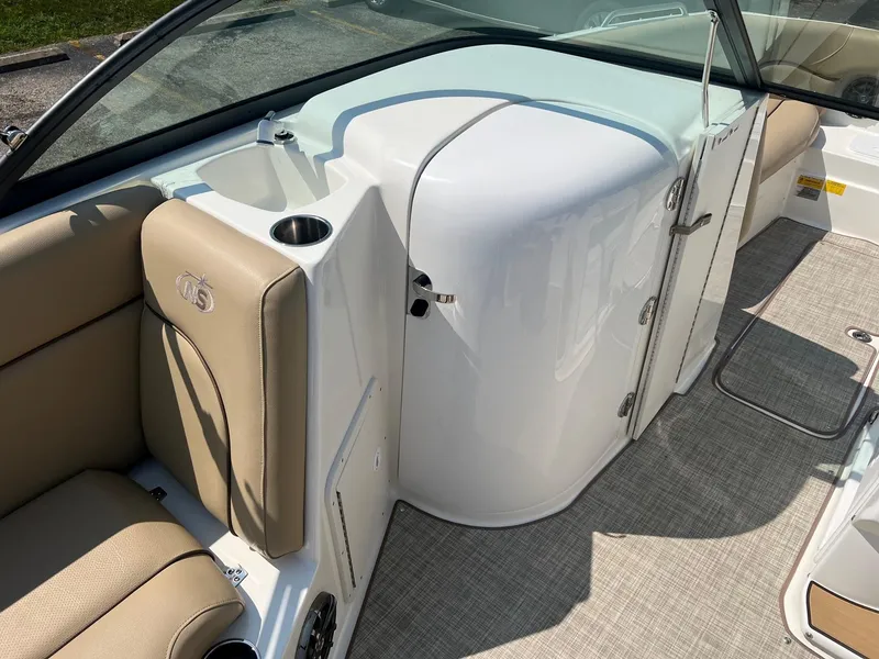 Slide: The Image of 2020 NauticStar 223 DC boat interior with beige seating and white console. - 7