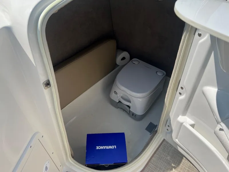Slide: The Image of 2020 NauticStar 223 DC boat interior with portable toilet and storage box. - 8