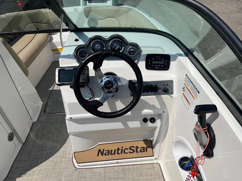 Slide: The Image of 2020 NauticStar 223 DC boat dashboard with steering wheel and control panel. - 9