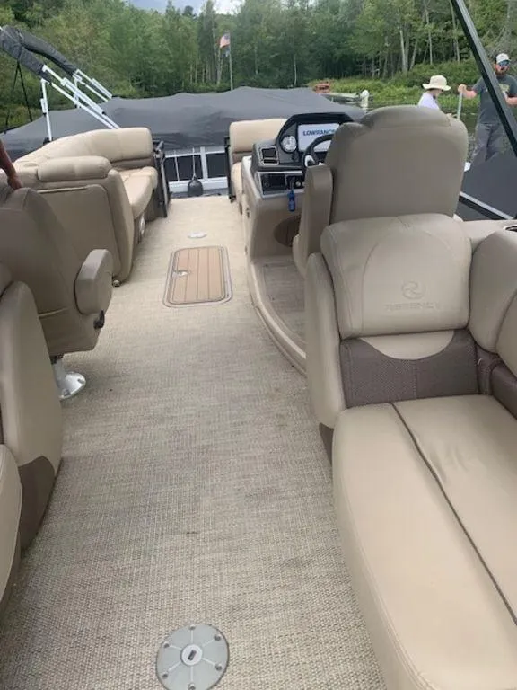 Slide: The Image of 2020 Regency 230 DL3 pontoon boat interior with beige seating and carpet. - 13