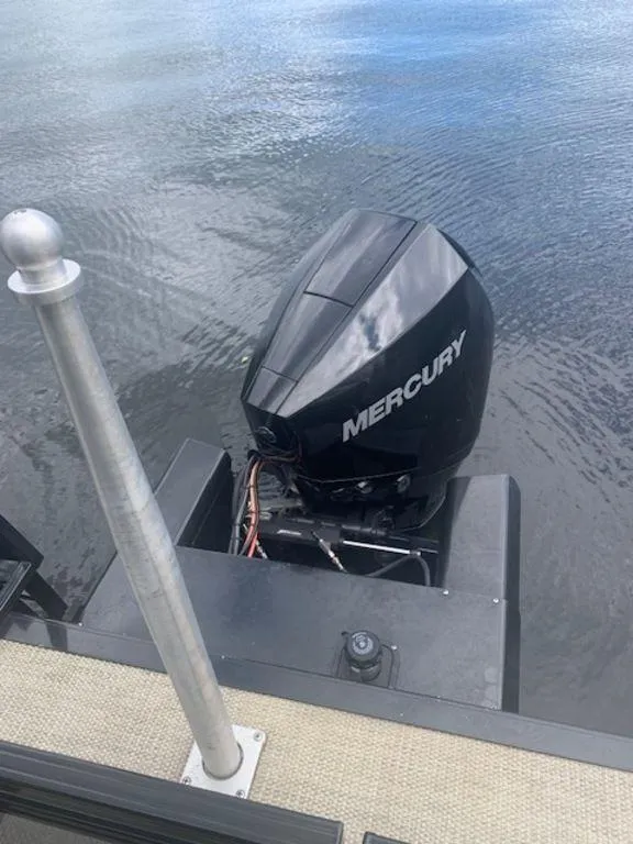 Slide: The Image of 2020 Regency 230 DL3 with Mercury outboard motor on calm water. - 14