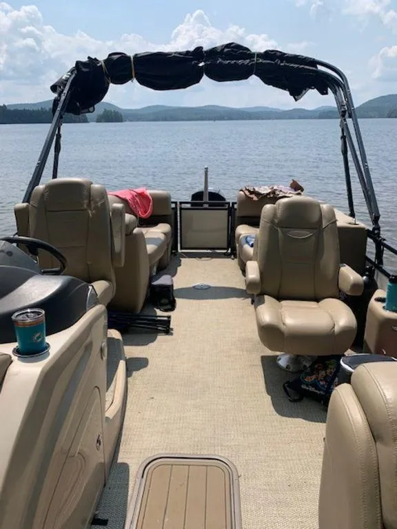 Slide: The Image of 2020 Regency 230 DL3 pontoon boat interior on a lake. - 2