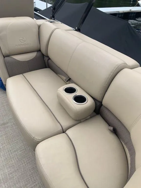 Slide: The Image of 2020 Regency 230 DL3 boat interior with beige leather seating and cup holders. - 23