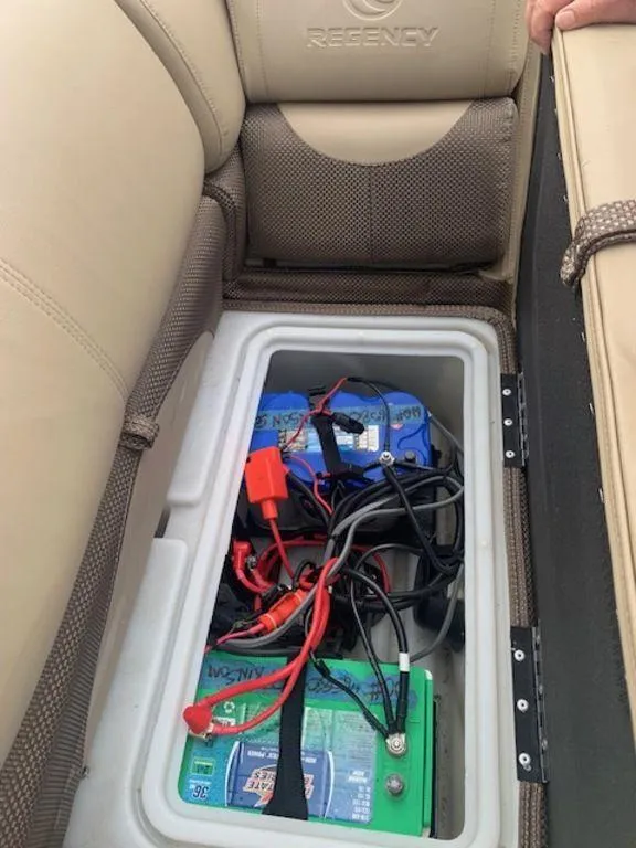 Slide: The Image of Battery compartment in 2020 Regency 230 DL3 boat, featuring wiring and storage under seat. - 26