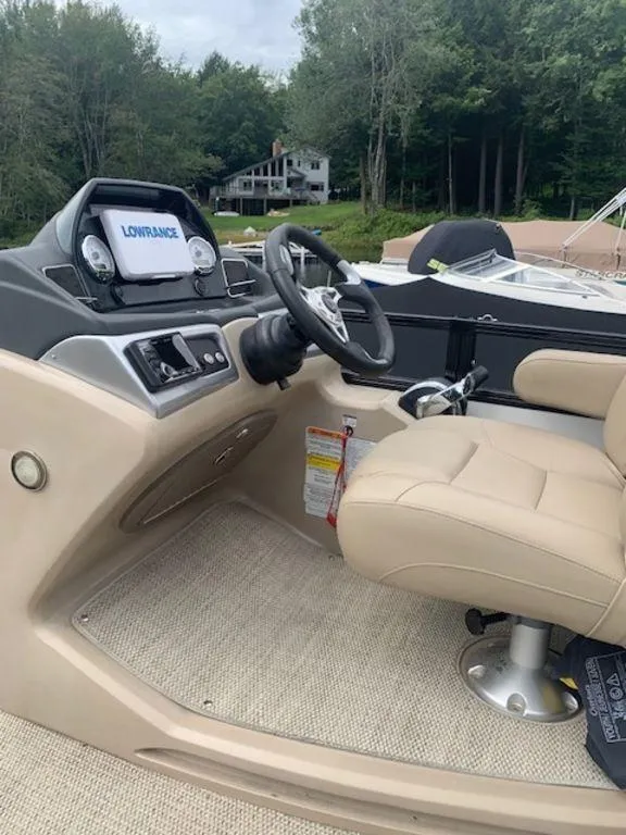 Slide: The Image of 2020 Regency 230 DL3 boat interior with steering wheel and navigation system. - 29