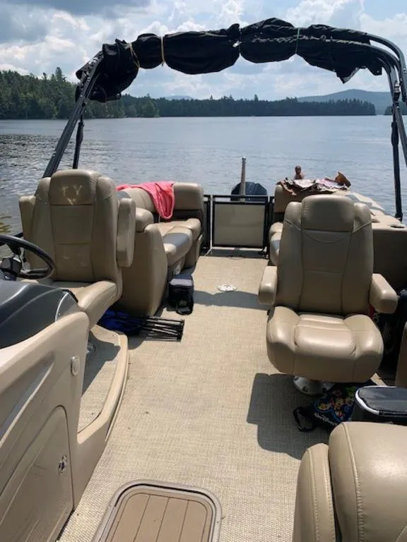 Slide: The Image of 2020 Regency 230 DL3 pontoon boat interior on a serene lake. - 3