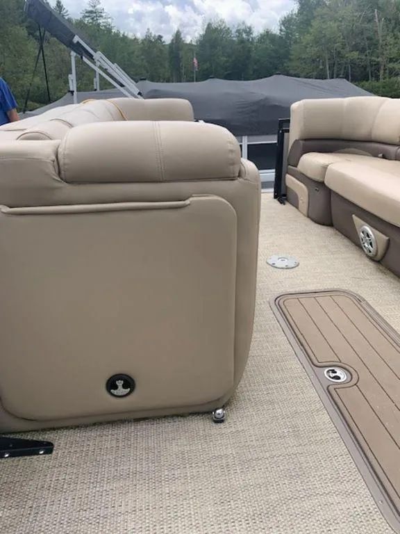 Slide: The Image of 2020 Regency 230 DL3 pontoon boat interior with beige seating and carpet flooring. - 30