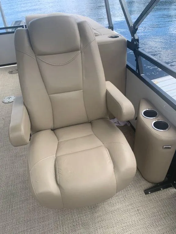 Slide: The Image of Beige captain's chair on 2020 Regency 230 DL3 boat, with cup holders and water view. - 33