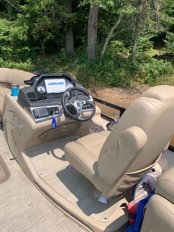 Slide: The Image of 2020 Regency 230 DL3 boat interior with steering console and beige seating. - 4