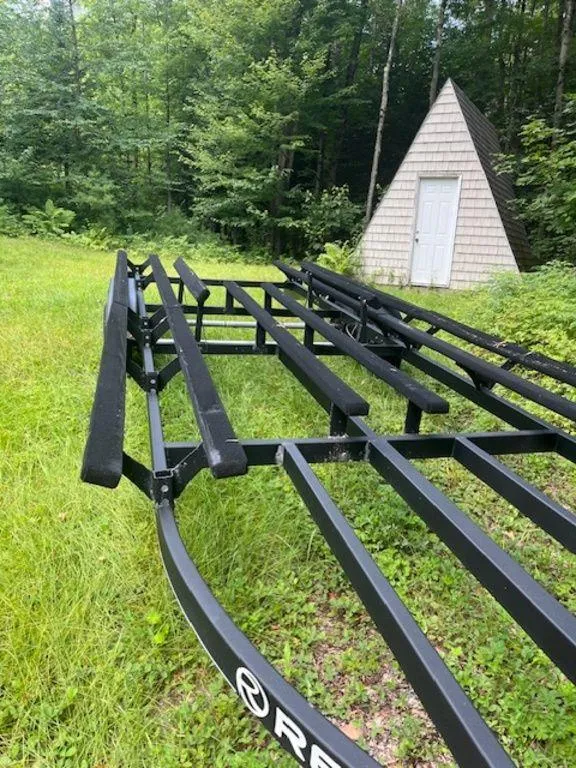 Slide: The Image of Regency 230 DL3 trailer frame in a grassy area near a small shed, 2020 model. - 48