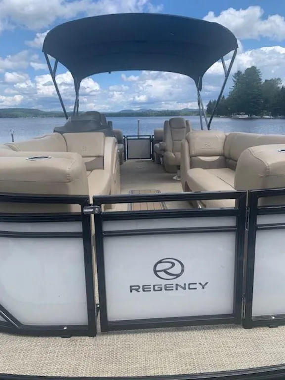 Slide: The Image of 2020 Regency 230 DL3 pontoon boat with canopy on a serene lake. - 9