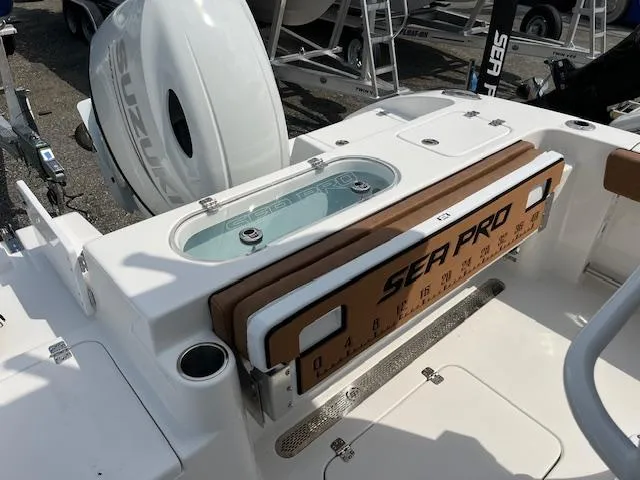 Slide: The Image of 2025 Sea Pro 222 DLX boat interior with Suzuki engine, featuring seating and storage. - 9