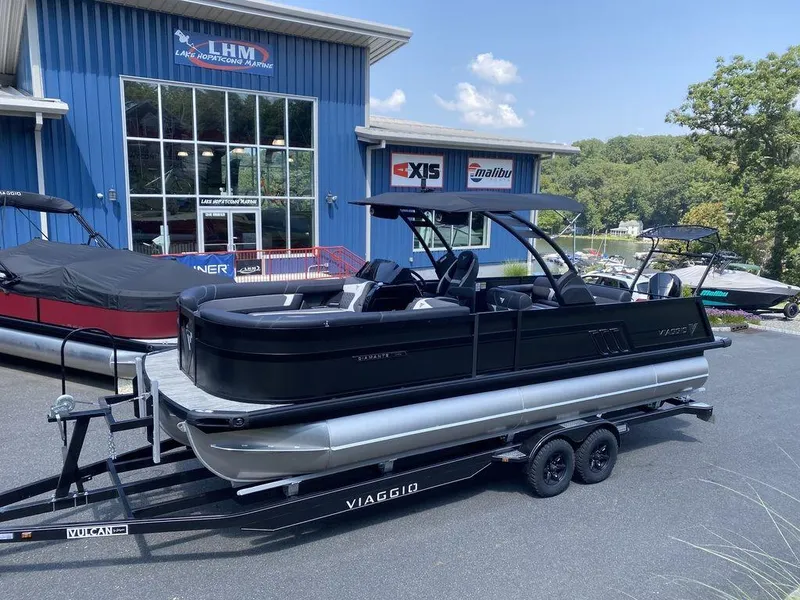 Slide: The Image of 2025 Viaggio Diamante 24S pontoon boat on trailer outside dealership. - 2
