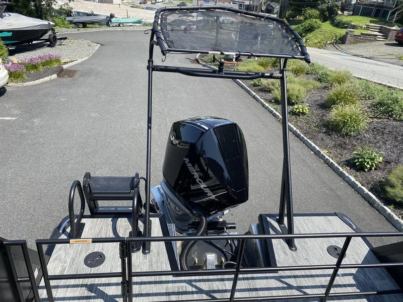 Slide: The Image of 2025 Viaggio Diamante 24S boat with outboard motor and canopy, parked on a driveway. - 22