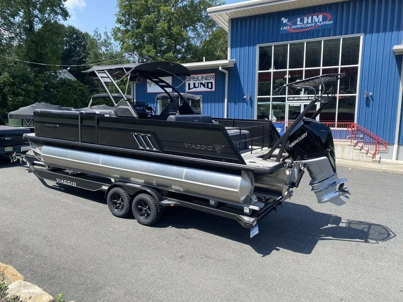 Slide: The Image of 2025 Viaggio Diamante 24S pontoon boat on trailer outside dealership. - 3
