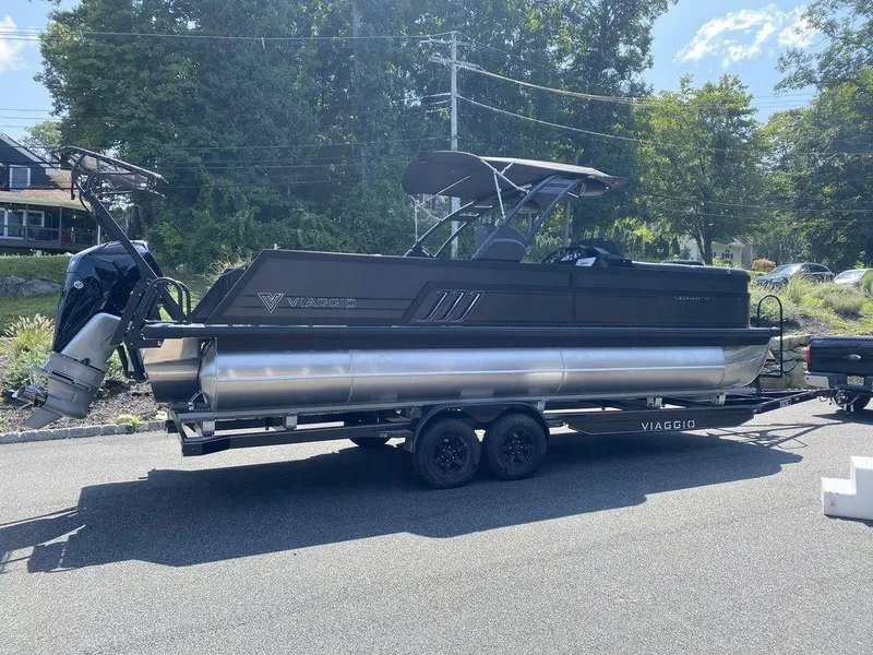 Slide: The Image of 2025 Viaggio Diamante 24S pontoon boat on trailer, parked outdoors. - 6