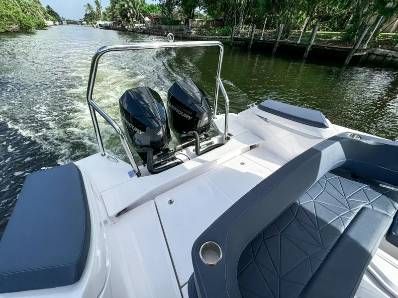 Slide: The Image of 2024 Axopar 29 Sun Top boat with dual Mercury engines cruising on a scenic waterway. - 18