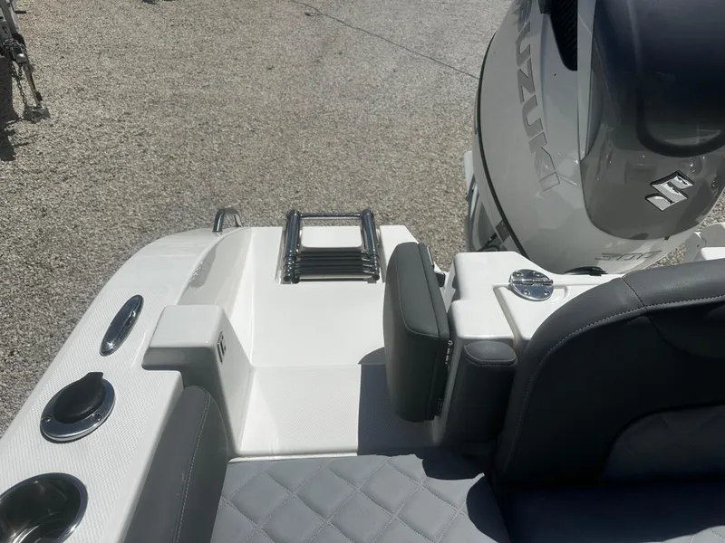 Slide: The Image of 2024 NauticStar 242 OSL boat with Suzuki engine, featuring sleek seating and cup holders. - 16