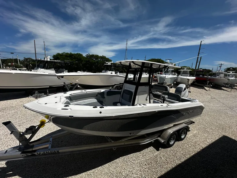 Slide: The Image of 2024 NauticStar 242 OSL boat on trailer under clear blue sky. - 20