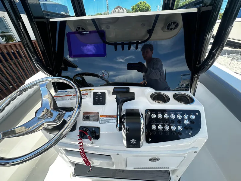 Slide: The Image of 2024 NauticStar 242 OSL boat dashboard with steering wheel and control panel. - 7