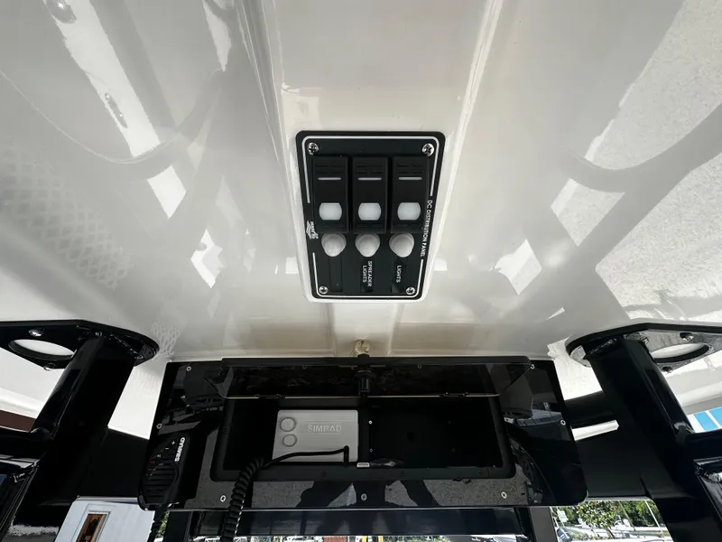 Slide: The Image of 2024 NauticStar 242 OSL boat control panel with switches and electronics. - 8