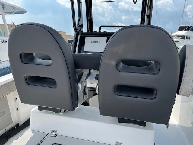 Slide: The Image of 2025 Sea Pro 245 FLX boat seats with Simrad display in background. - 12