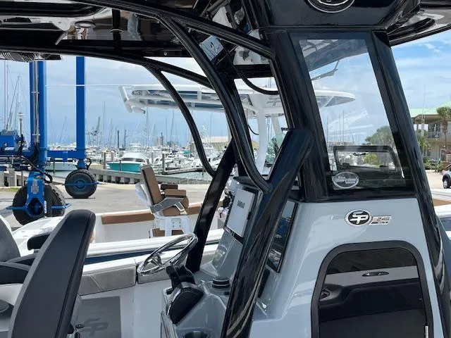 Slide: The Image of 2025 Sea Pro 245 FLX boat interior at marina, showcasing helm and seating area. - 15