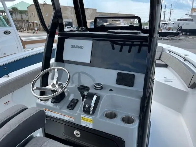 Slide: The Image of 2025 Sea Pro 245 FLX boat console with steering wheel and Simrad display. - 7