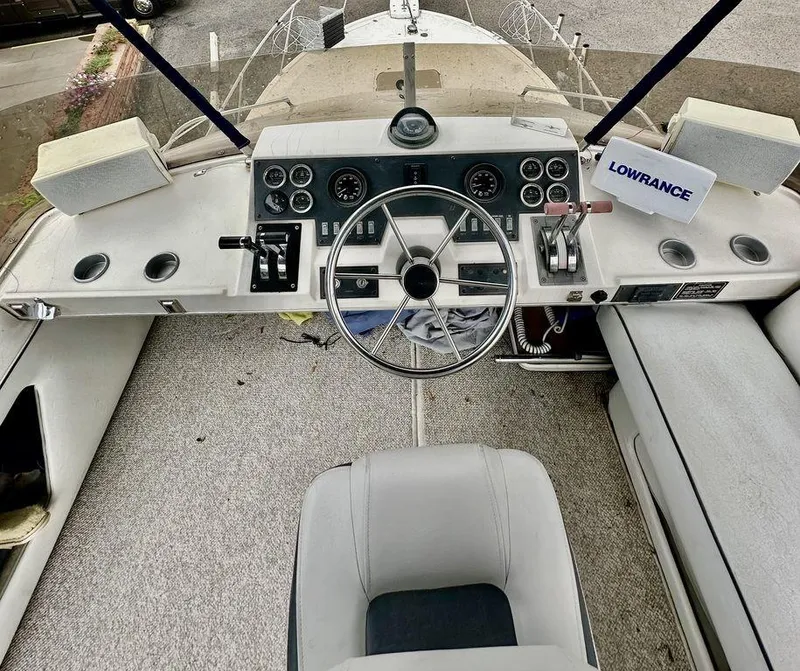 Slide: The Image of 1986 Bayliner 2850 Command Bridge helm with steering wheel and control panel. - 10