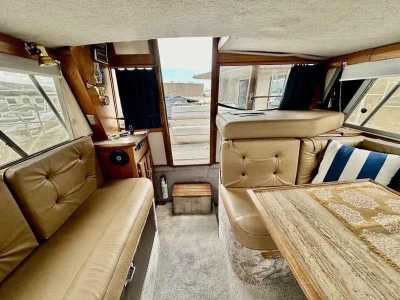 Slide: The Image of Interior of 1986 Bayliner 2850 Command Bridge with tan seating and wooden table. - 12