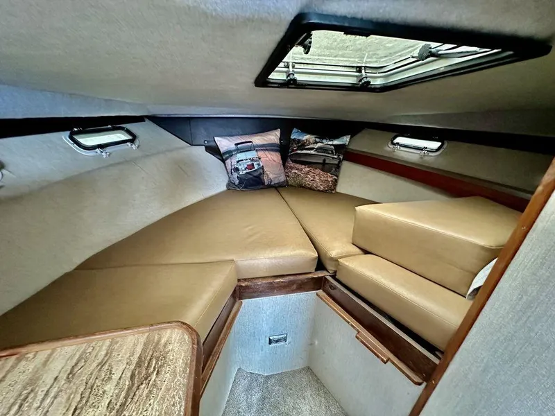 Slide: The Image of Cozy cabin interior of 1986 Bayliner 2850 Command Bridge with tan cushions and pillows. - 17