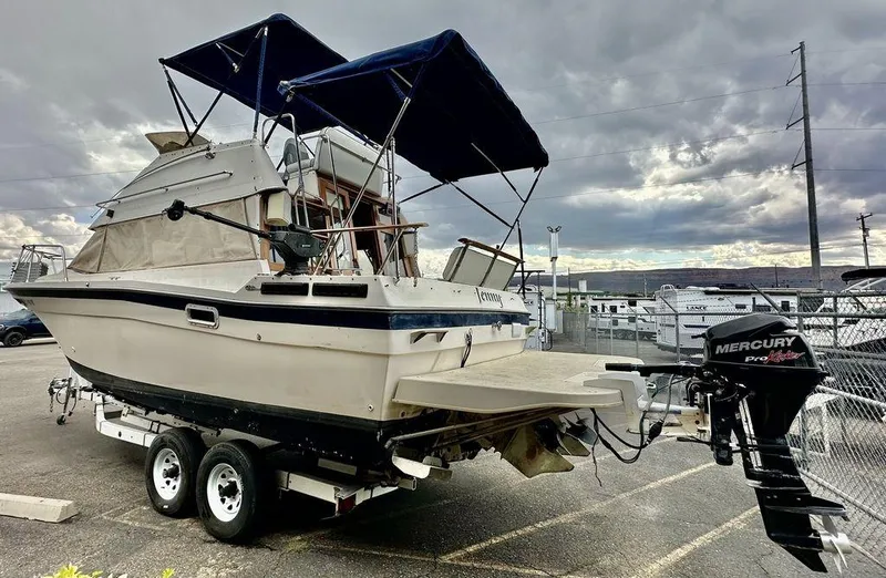 Slide: The Image of 1986 Bayliner 2850 Command Bridge boat on trailer with Mercury outboard motor. - 5