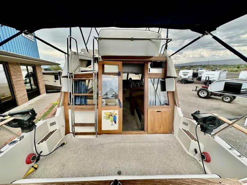 Slide: The Image of 1986 Bayliner 2850 Command Bridge boat interior with carpeted deck and wooden cabin doors. - 8