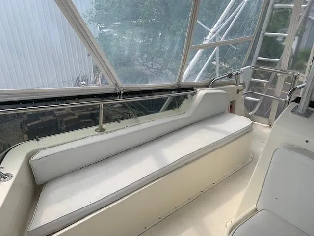 Slide: The Image of 1988 Hatteras 48 Convertible boat interior with white seating and large windows. - 11