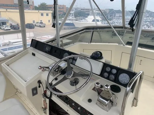Slide: The Image of 1988 Hatteras 48 Convertible yacht helm with steering wheel and control panel. - 12