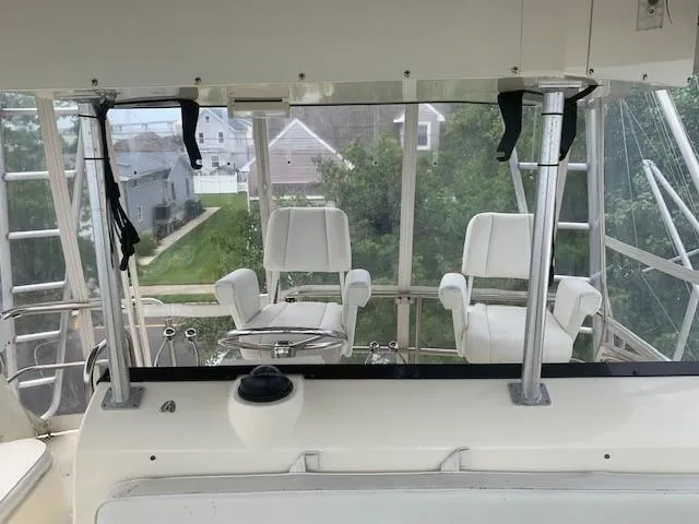 Slide: The Image of Interior view of 1988 Hatteras 48 Convertible yacht helm with white captain chairs. - 14