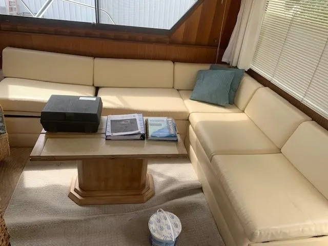 Slide: The Image of Interior of 1988 Hatteras 48 Convertible yacht with cream seating and wooden table. - 17