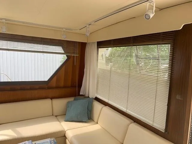 Slide: The Image of Interior of 1988 Hatteras 48 Convertible yacht with beige seating and large windows. - 18