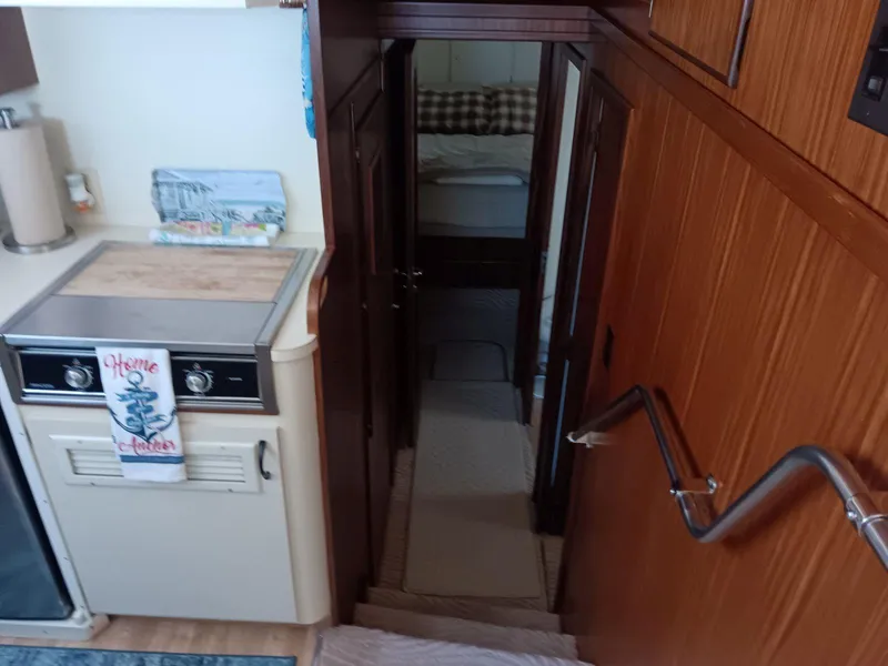 Slide: The Image of Interior of 1988 Hatteras 48 Convertible yacht, featuring kitchen and hallway to bedroom. - 23