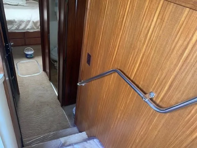 Slide: The Image of Interior hallway of 1988 Hatteras 48 Convertible yacht with wood paneling and carpeted floor. - 24