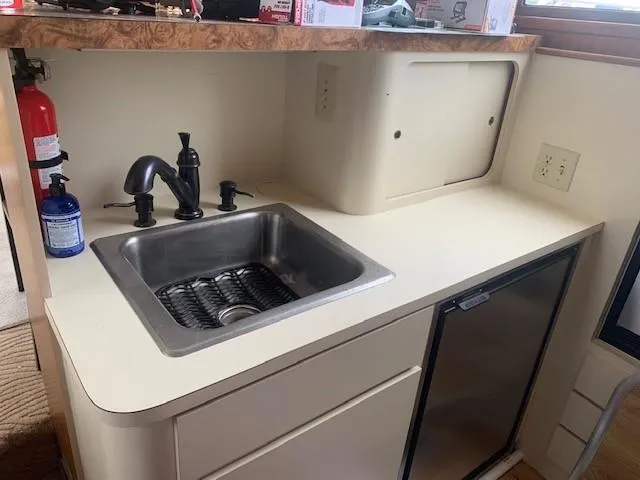 Slide: The Image of 1988 Hatteras 48 Convertible yacht kitchenette with sink and mini fridge. - 26