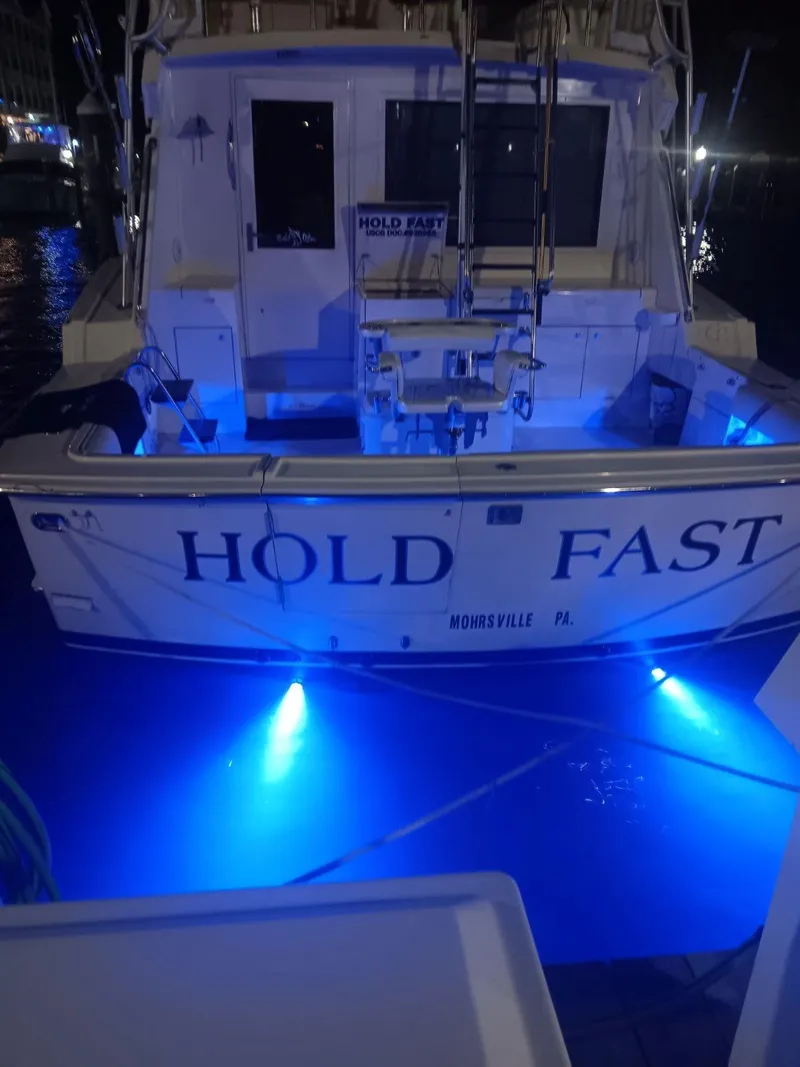 Slide: The Image of Hatteras 48 Convertible 1988 boat "Hold Fast" with blue underwater lights at night. - 3