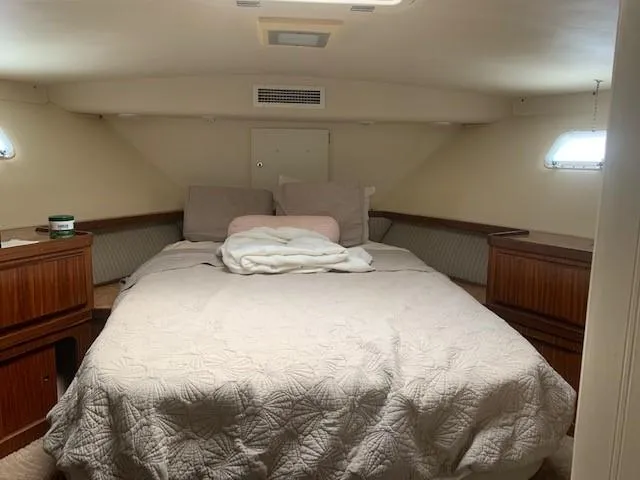 Slide: The Image of Cozy bedroom interior of 1988 Hatteras 48 Convertible yacht with quilted bedding. - 39