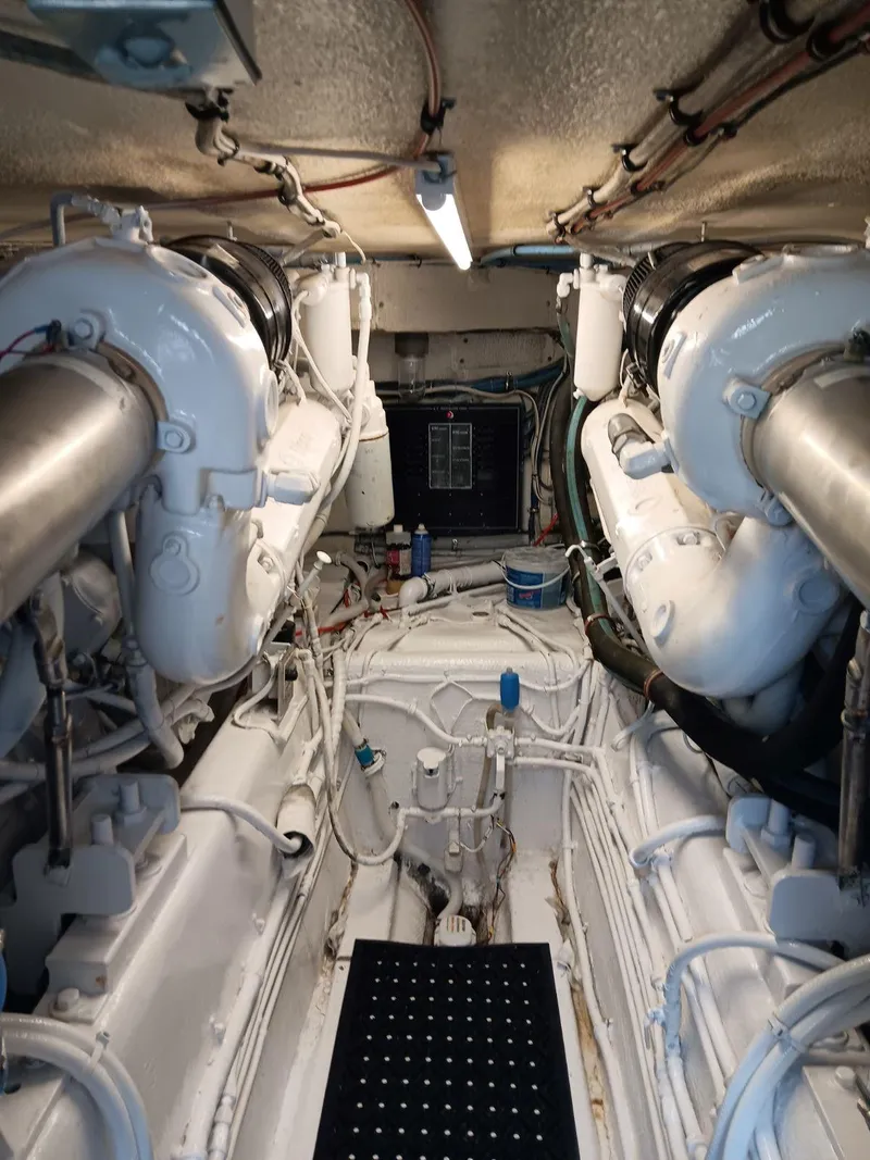 Slide: The Image of Engine room of 1988 Hatteras 48 Convertible yacht, featuring dual engines and piping. - 41