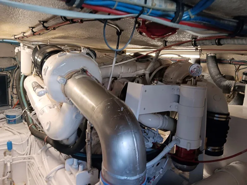 Slide: The Image of Engine room of 1988 Hatteras 48 Convertible yacht, showcasing complex machinery and piping. - 42